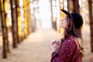 Foto grátis foto de foco seletivo de uma linda jovem orando em uma floresta