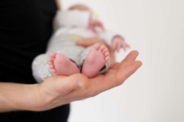 Foto de foco seletivo de uma pessoa carregando um bebê recém-nascido