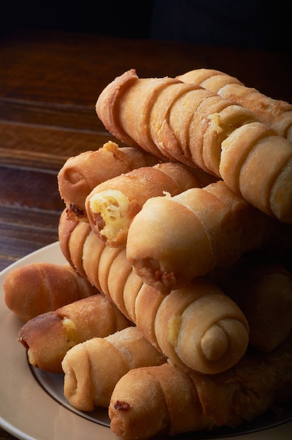 Foto de foco seletivo vertical de corndogs em um prato com um fundo escuro