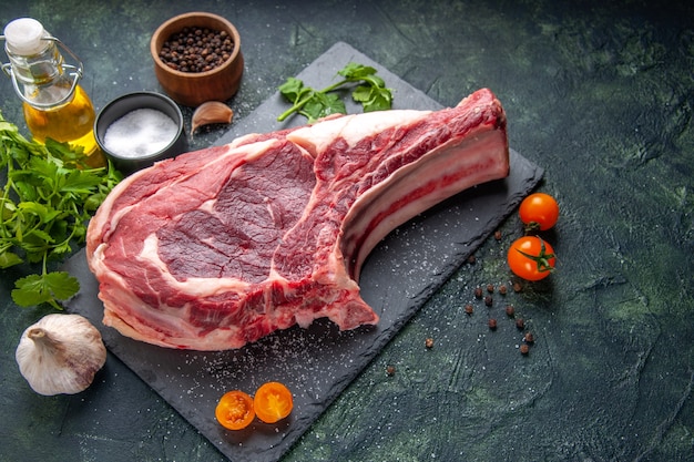 Foto de frente, grande fatia de carne, carne crua com pimenta e verduras no escuro, farinha de frango, churrasco de animais, açougueiro