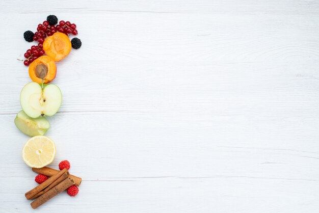 Foto de frutas frescas fatiadas coloridas e maduras com canela no fundo branco