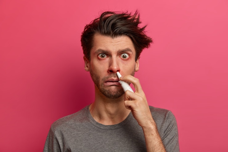 Foto grátis foto de homem doente que sofre de rinite, tem nariz entupido, olhos vermelhos, espalha remédios para alergia, reage a vários gatilhos, sofre de febre e resfriado, tenta respirar livremente. pessoas, conceito de doença