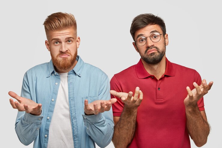 Foto grátis foto de homens barbudos hesitantes com expressão sem noção, trabalham juntos em equipe, não sabem fazer um projeto bem-sucedido, usam roupas da moda e óculos redondos, sendo inteligente e trabalhador