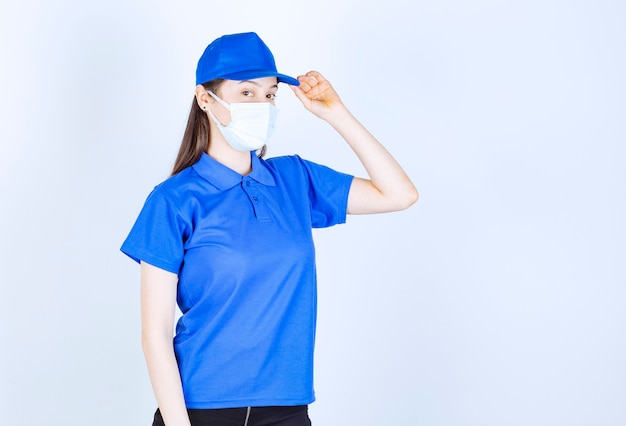 Foto de jovem de uniforme usando máscara médica e posando.