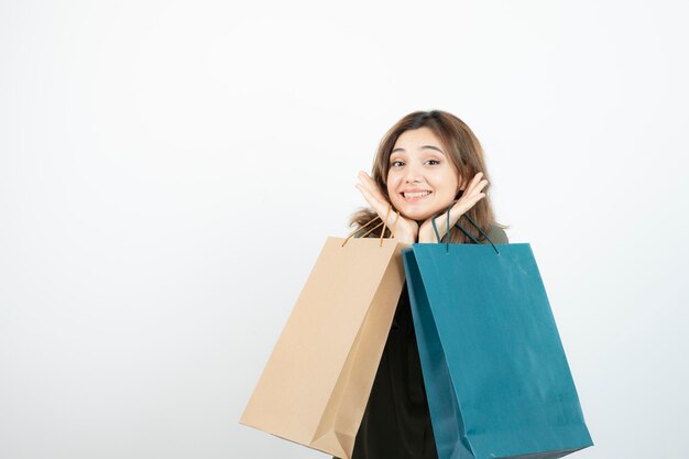 Foto de jovem feliz segurando sacolas de compras sobre branco. foto de alta qualidade