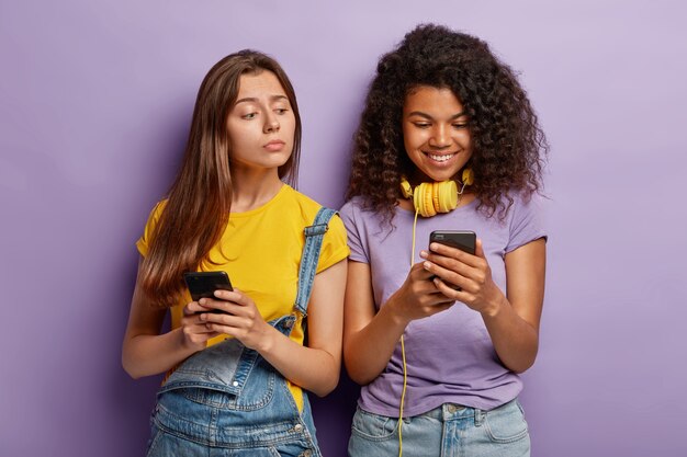 Foto de jovens namoradas posando com seus telefones