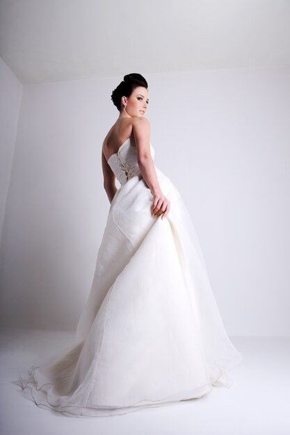 Foto de moda da bela jovem noiva vestida de vestido de noiva branco
