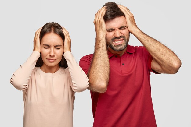 Foto de mulher deprimida estressante e homem com terrível dor de cabeça enquanto trabalha dia e noite, tem prazo