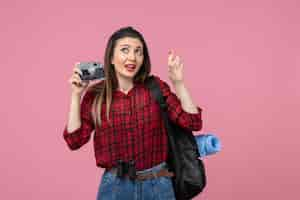 Foto grátis foto de mulher jovem de frente para a foto com a câmera em cores de mulher de foto de fundo rosa