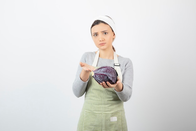 Foto de mulher jovem mostrando repolho roxo em branco