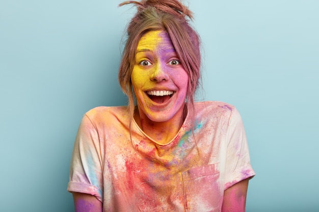 Foto grátis foto de mulher otimista brincando com cores no festival holi, vestida com uma camiseta branca