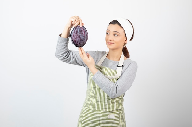 Foto de mulher positiva olhando para repolho roxo em branco