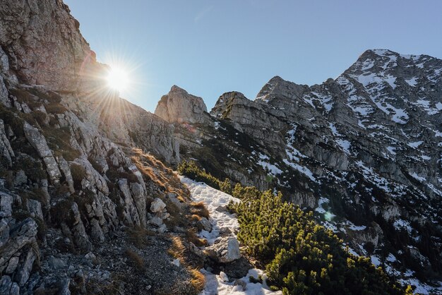Foto de paisagem de montanhas nevadas com o sol brilhando