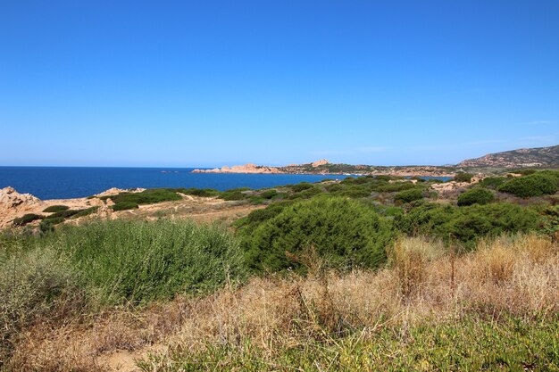 Foto de paisagem de uma estrada costeira com um céu azul claro