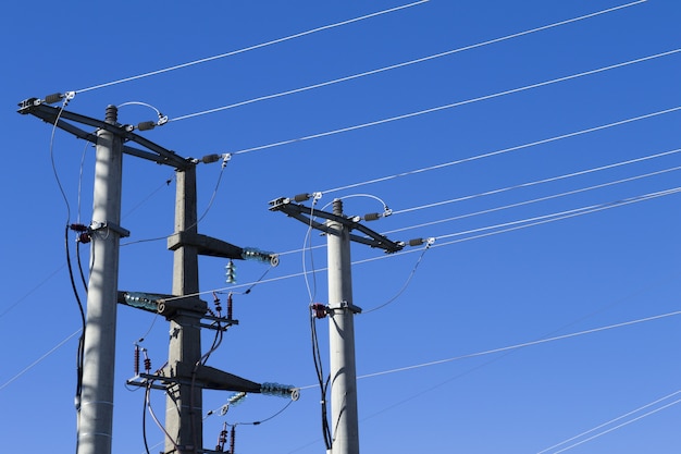 Foto de postes e cabos elétricos contra um fundo azul