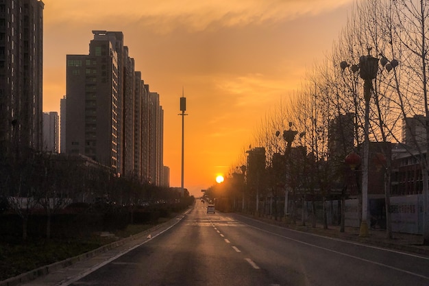 Foto de tirar o fôlego de um pôr do sol na rua no meio de uma cidade moderna