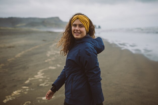 Foto de um modelo, apreciando o ar fresco da praia em um dia frio de outono