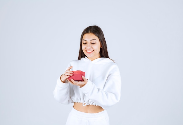 Foto de um modelo de menina bonita segurando uma caixa de presente.