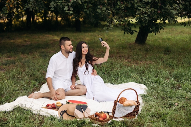 Foto de uma jovem alegre, branca, do sexo feminino e masculino segurando o filho nas mãos, sorrindo e se alegrando