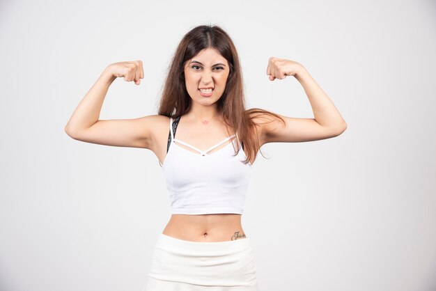 Foto de uma jovem mulher desportiva, mostrando seu bíceps.