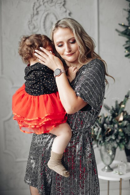 Foto de uma linda mãe segurando seu daghter nas mãos e a abraçando