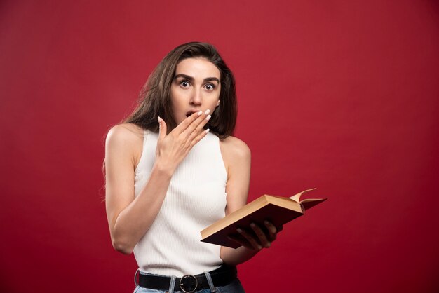 Foto de uma linda senhora segurando um livro