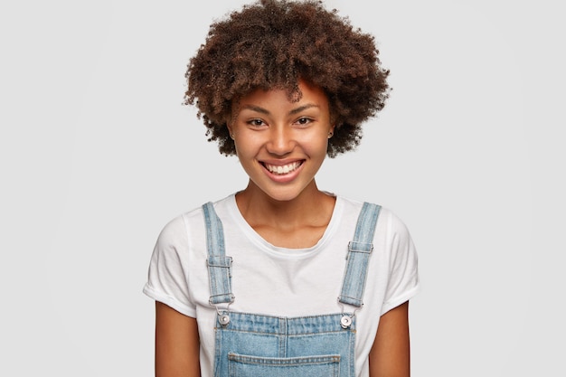 Foto de uma mulher sorridente com uma expressão feliz, alegra algo bom na vida, vestida com roupas casuais