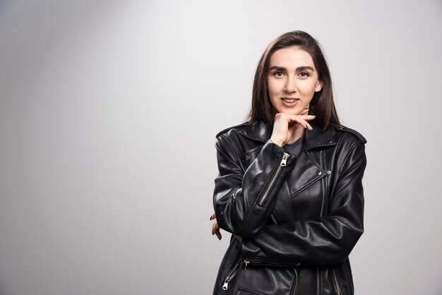 Foto de uma mulher sorridente posando com uma jaqueta de couro preta