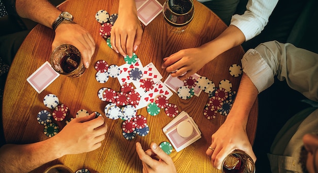 Foto de vista superior de amigos sentados na mesa de madeira. amigos se divertindo enquanto jogava jogo de tabuleiro.