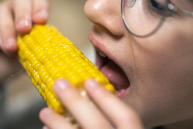 Foto detalhada de uma garota comendo milho