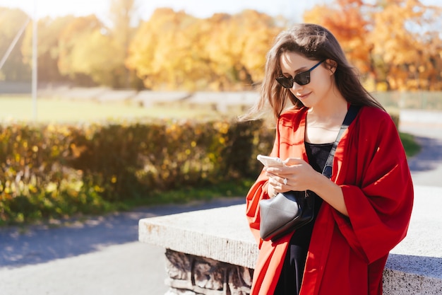 Foto do retrato de uma jovem garota com um smartphone