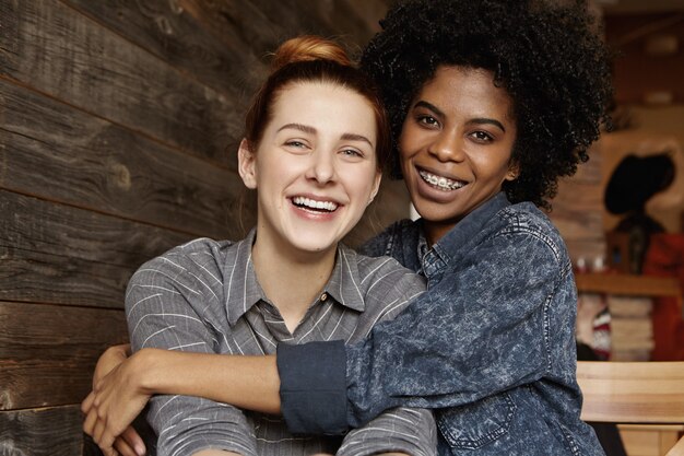 Foto doce de casal gay inter-racial feliz desfrutando de seu amor livre, se abraçando e se abraçando