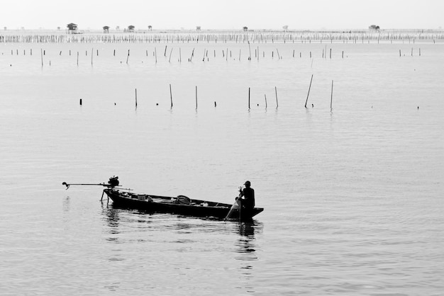 Foto grátis foto em escala de cinza de uma pessoa em um barco a motor no meio de um mar calmo