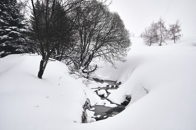 Foto em preto e branco de um riacho fluindo pela estação de esqui Alpe d Huez, nos Alpes franceses