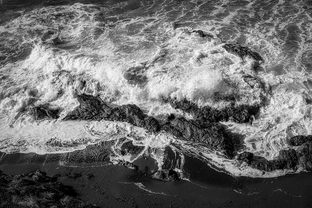 Foto em preto e branco de vista superior de um litoral coberto por rochas