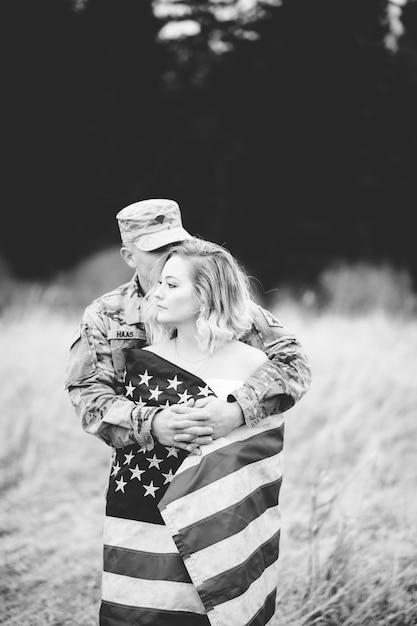 Foto em tons de cinza de um soldado americano abraçando sua esposa