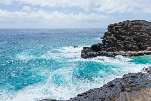 Foto hipnotizante da costa com um penhasco no fundo de um céu nublado