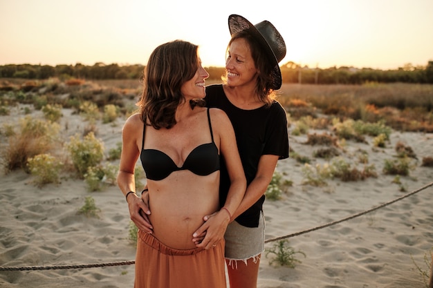 Foto hipnotizante de um lindo casal grávida - conceito de família lésbica