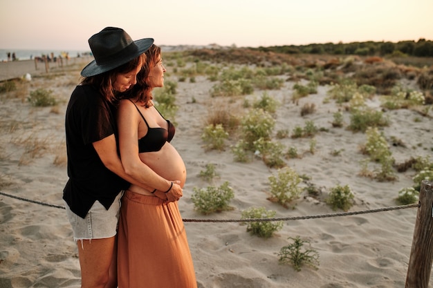 Foto hipnotizante de um lindo casal grávida - conceito de família lésbica