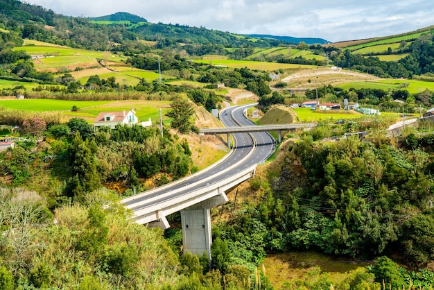 Foto hipnotizante de uma bela estrada cercada por vegetação