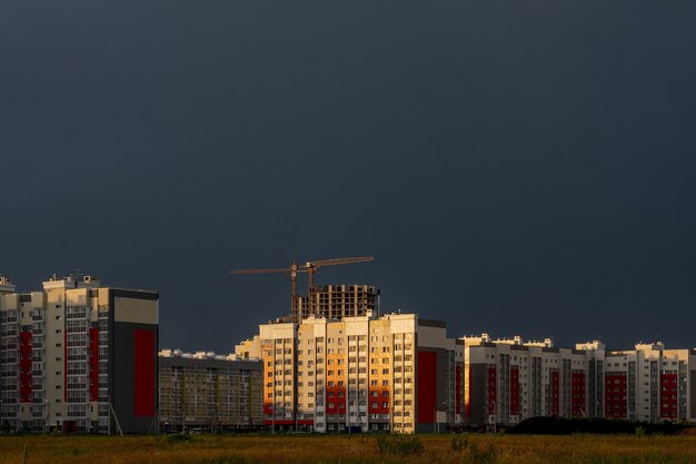 Foto horizontal de edifícios no canteiro de obras sob um céu nublado ao pôr do sol