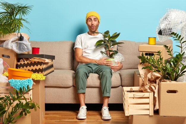 Foto horizontal de um jovem elegante surpreso por ter uma casa tão grande