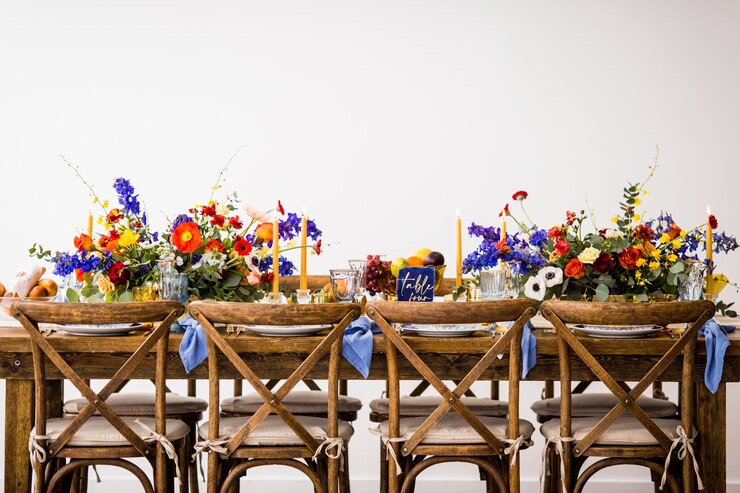 Foto grátis foto horizontal de uma mesa com cadeiras de madeira decorada com flores coloridas e velas