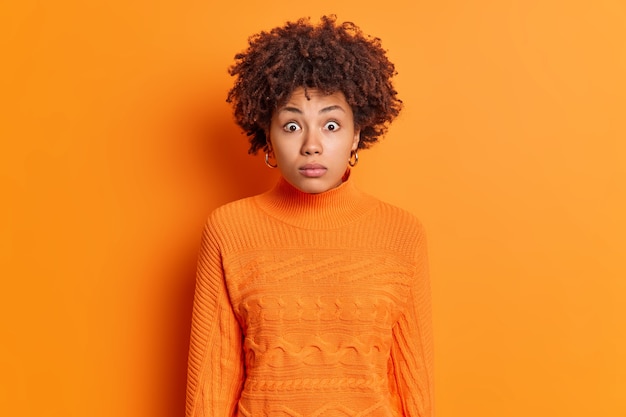 Foto grátis foto horizontal de uma mulher afro-americana em choque olhando para a câmera com uma expressão omg atordoada