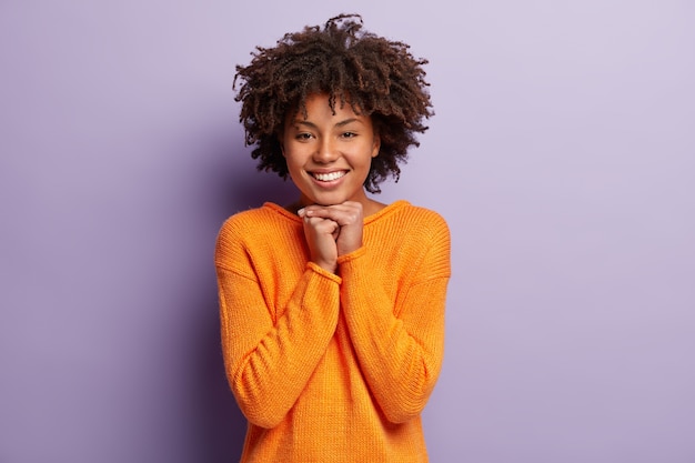 Foto horizontal de uma mulher afro-americana feliz com um sorriso cheio de dentes