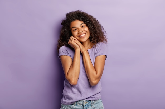 Foto horizontal de uma mulher bonita e macia de pele escura com cabelo encaracolado, cabeça inclinada e encontro romântico com namorado