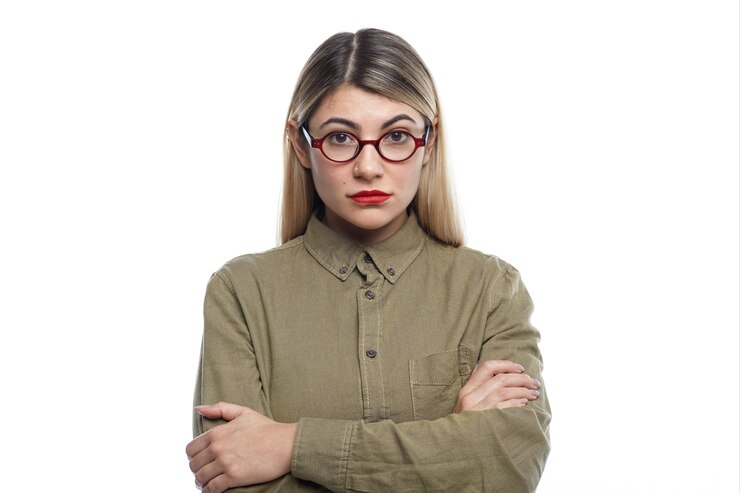 Foto grátis foto horizontal de uma mulher jovem e atraente com cabelo loiro solto e lábios vermelhos, mantendo os braços cruzados, sua aparência e postura expressando antipatia ou discordância sobre alguma ideia ou decisão de negócios