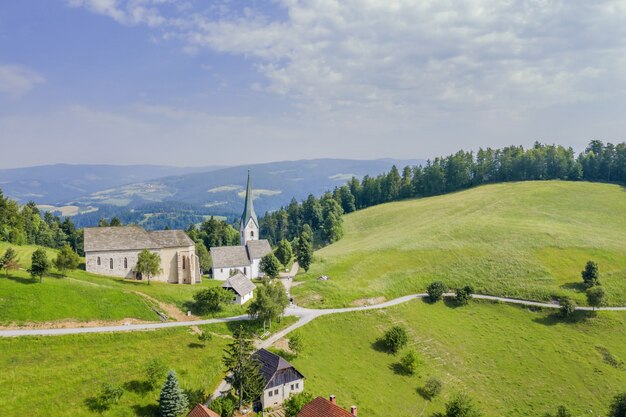 Foto incrível da igreja Lese na Eslovênia em um vale com céu nublado