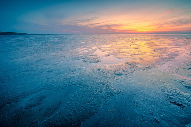 Foto incrível de uma paisagem marinha durante um clima frio no pôr do sol