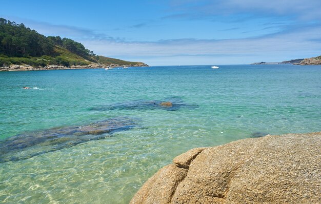 Foto incrível de uma praia rochosa sob o sol